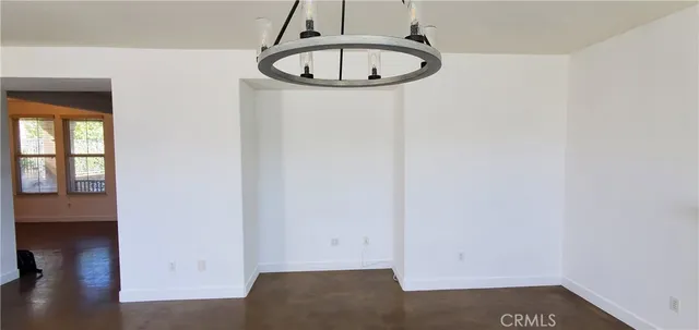 an empty room with a window and wooden floor