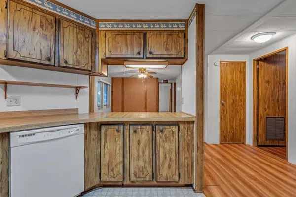 a view of a kitchen with wooden floor and cabinets
