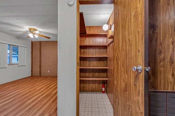 a view of a hallway with wooden floor and closet
