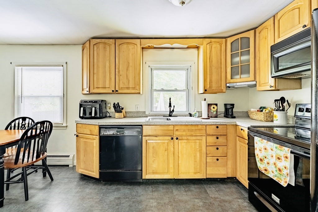 52 Embassy Road Springfield, MA 01119 - Photo 12 of 27 a kitchen with granite countertop wooden cabinets a stove a sink and a window