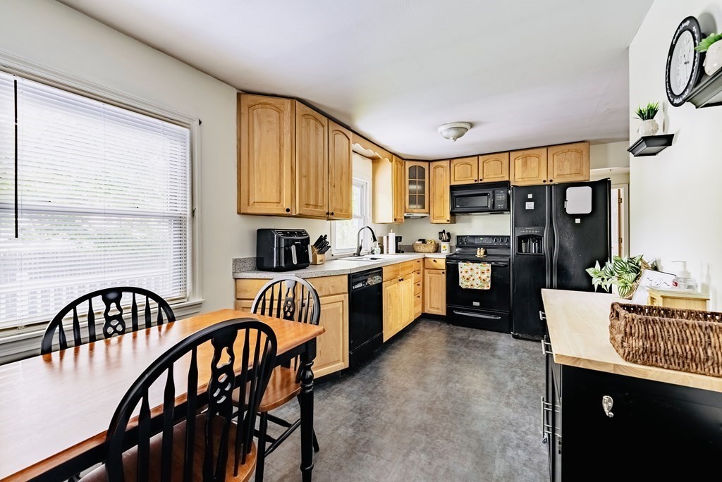 52 Embassy Road Springfield, MA 01119 - Photo 14 of 27 a kitchen with a table chairs refrigerator and cabinets