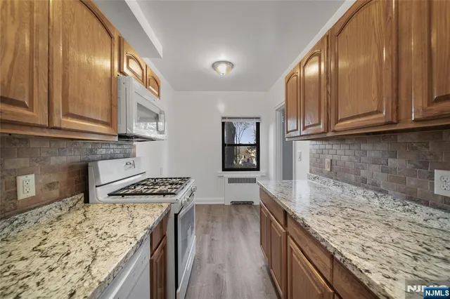 a kitchen with stainless steel appliances granite countertop a stove sink and cabinets