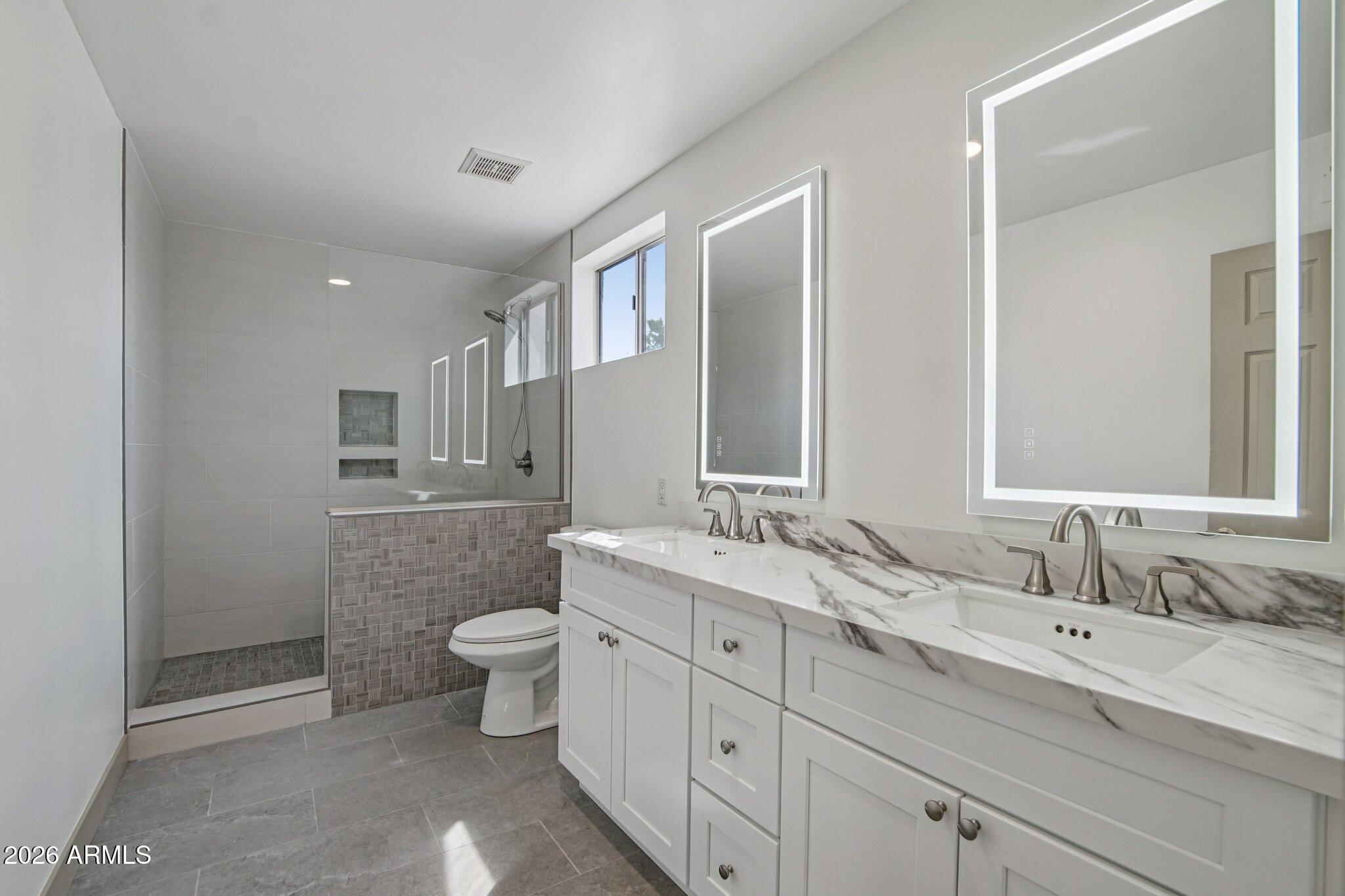 4662 East Grandview Road Phoenix, AZ 85032 - Photo 23 of 42 a spacious bathroom with a double vanity sink mirror and toilet