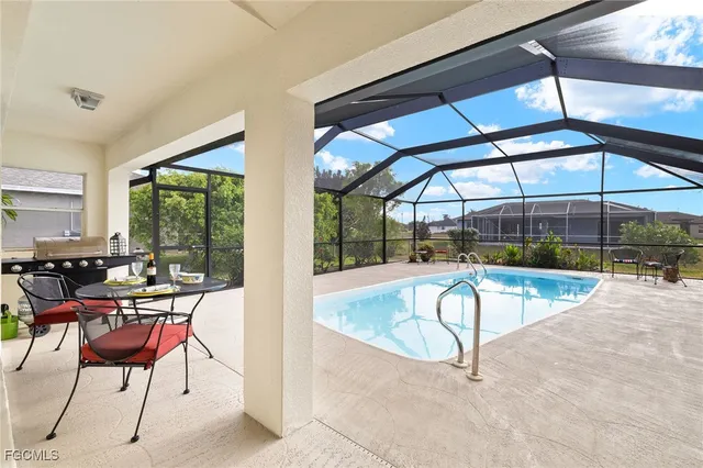 a view of a swimming pool with a table and chairs under an umbrella
