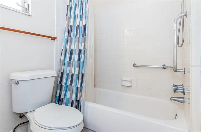 a white toilet and tub sitting next to a bathroom sink
