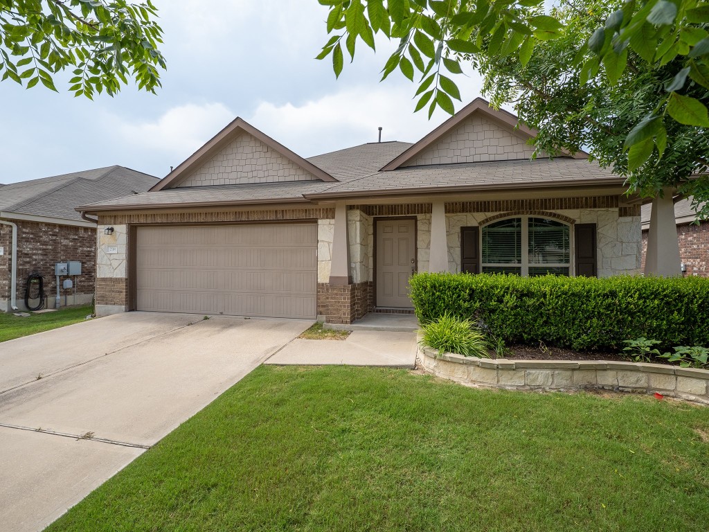 a front view of a house with a yard and garage