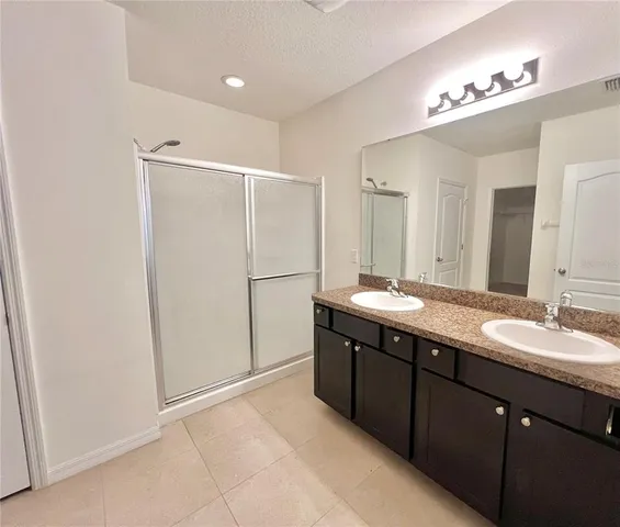 a bathroom with a double vanity sink and mirror