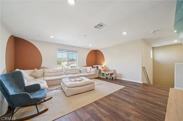 a view of a white house next to a yard with potted plants