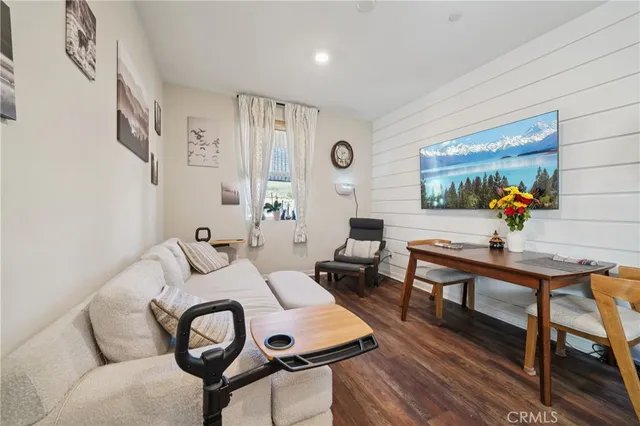 a view of a white house next to a yard with potted plants