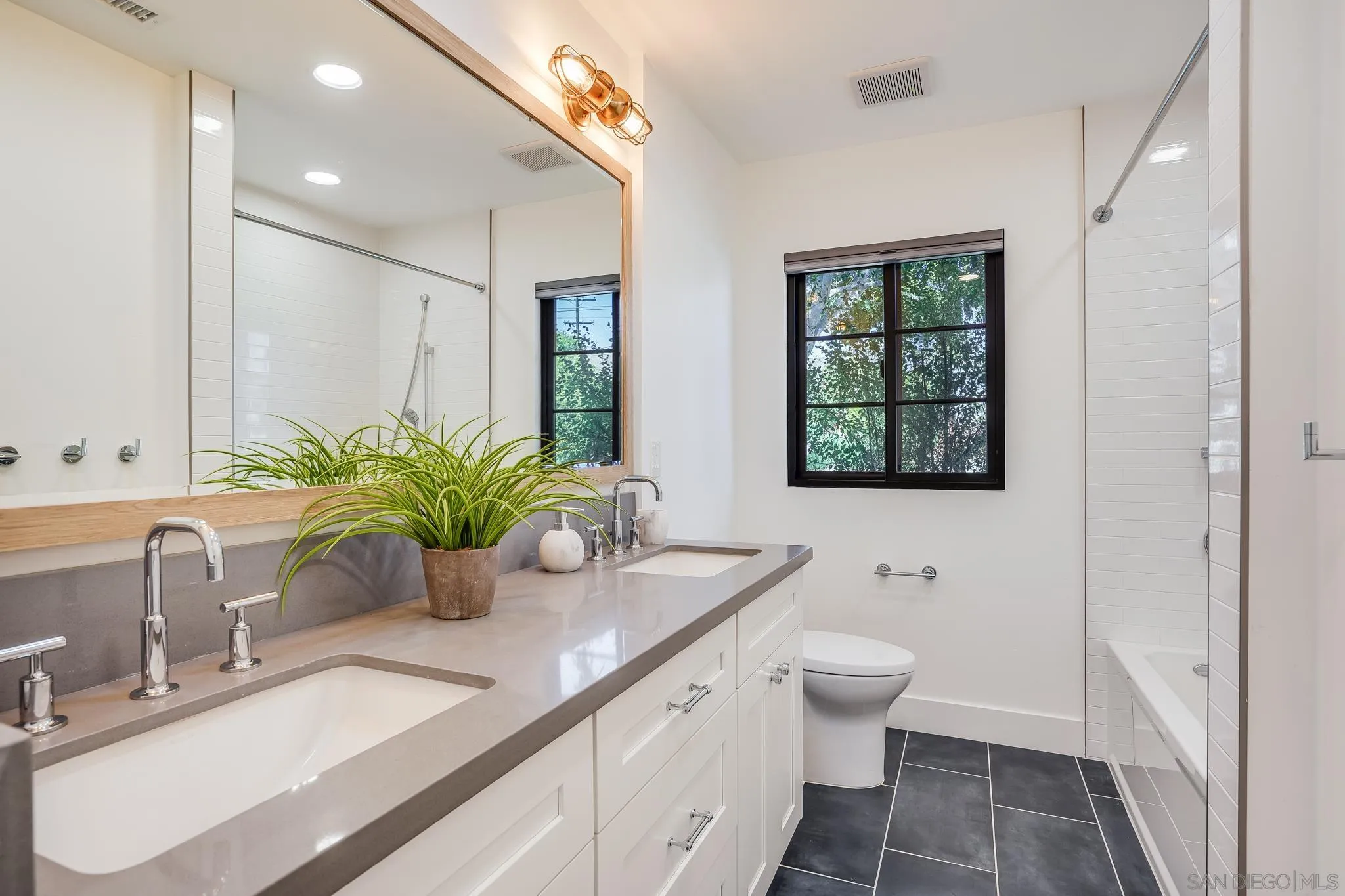 8804 Robinhood Lane La Jolla, CA 92037 - Photo 29 of 58 a bathroom with a granite countertop sink a large mirror a toilet and a shower