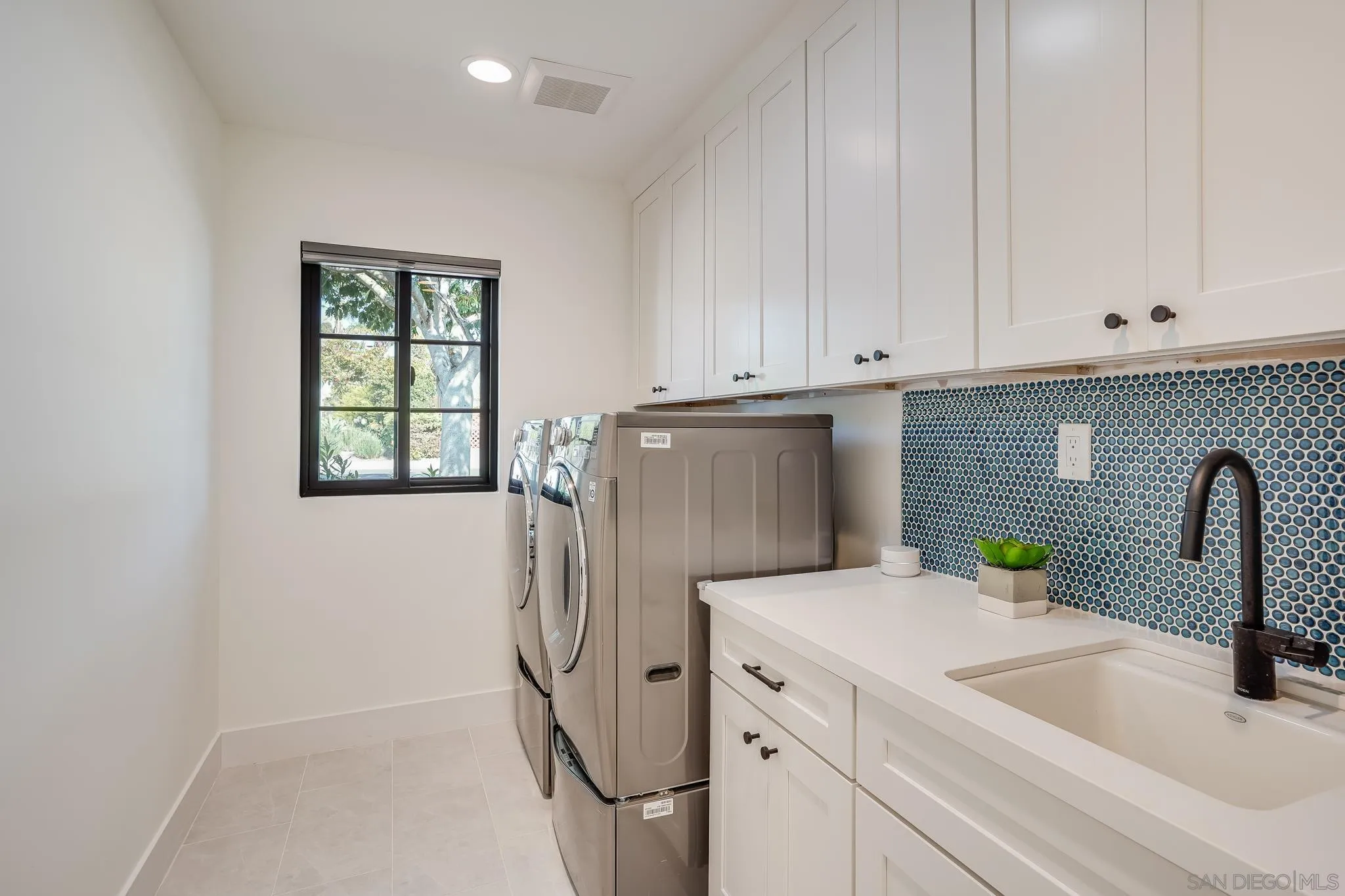8804 Robinhood Lane La Jolla, CA 92037 - Photo 39 of 58 a kitchen with a refrigerator sink and white cabinets