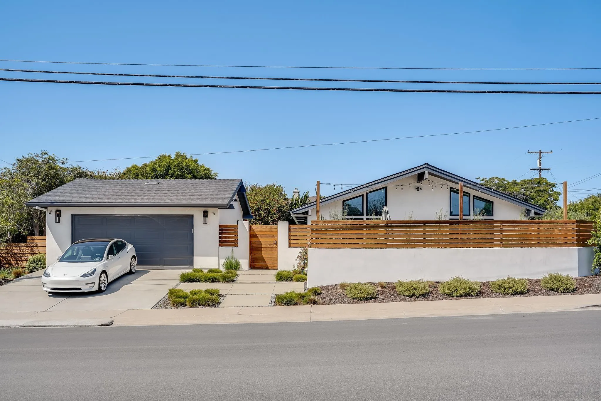 8804 Robinhood Lane La Jolla, CA 92037 - Photo 4 of 58 a front view of a house with a yard and garage