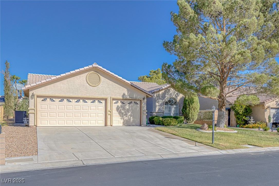 5333 Rim View Lane Las Vegas, NV 89130 - Photo 1 of 55 Single story home featuring an attached garage, concrete driveway, stucco siding, a tiled roof, and a front yard