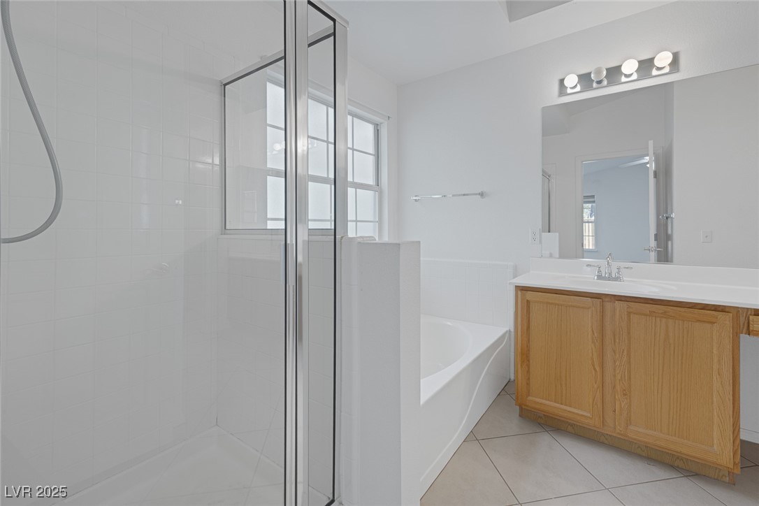 5333 Rim View Lane Las Vegas, NV 89130 - Photo 27 of 55 Full bath featuring a shower stall, a garden tub, vanity, and light tile patterned floors