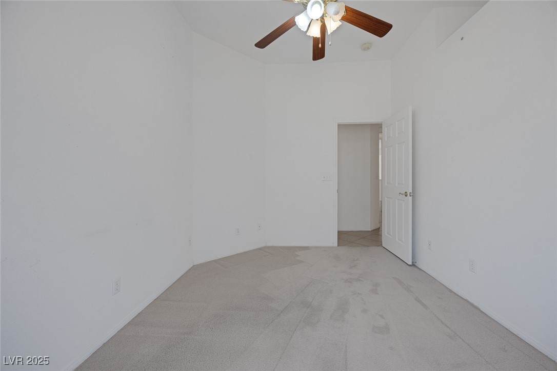 5333 Rim View Lane Las Vegas, NV 89130 - Photo 34 of 55 bedroom adjacent to primary; can be office/nursery/hobby room ... light colored carpet and ceiling fan