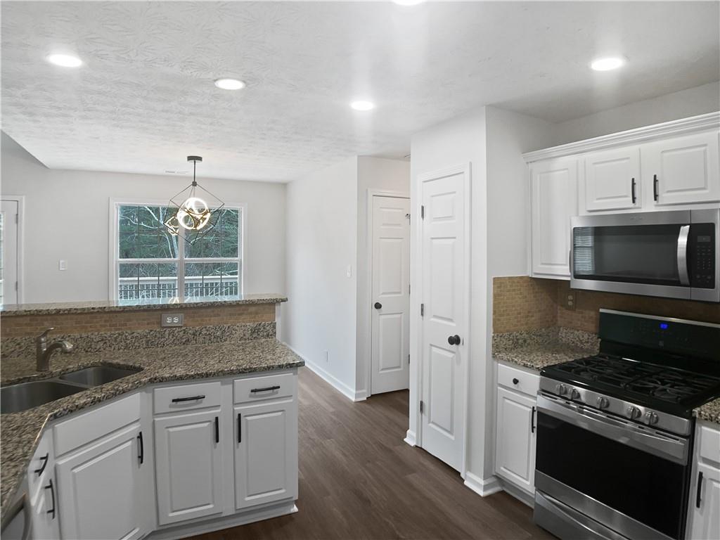 1780 North Round Road Lawrenceville, GA 30045 - Photo 7 of 24 a kitchen with granite countertop a sink cabinets and stainless steel appliances