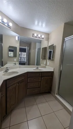 a bathroom with a granite countertop sink a large mirror and a bathtub