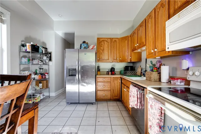 a kitchen with stainless steel appliances granite countertop a refrigerator and a stove top oven