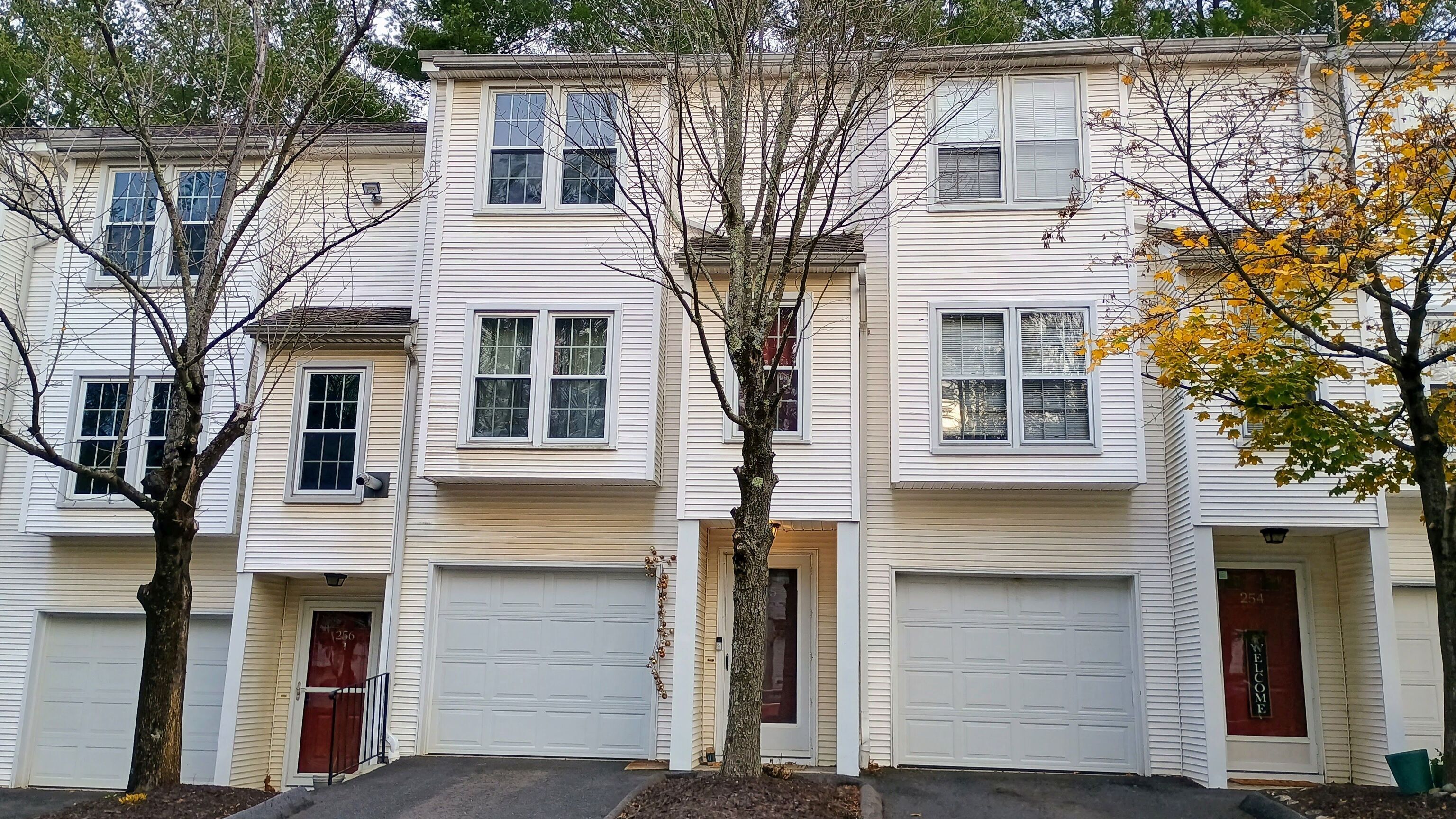a front view of a house with a tree