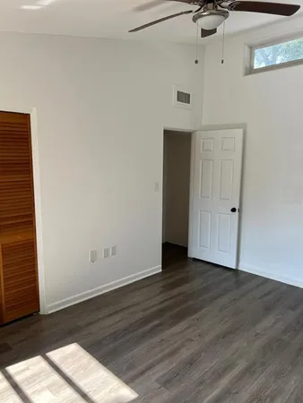 a view of an empty room with wooden floor