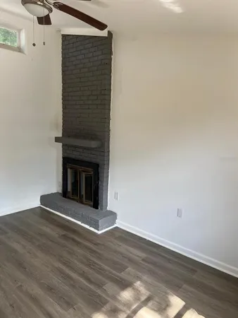 a view of empty room with wooden floor and fireplace