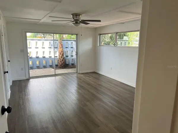 an empty room with wooden floor and windows