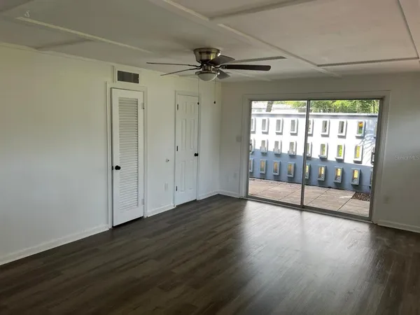 a view of a livingroom with wooden floor and a ceiling fan