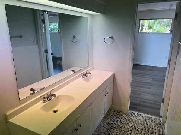 a bathroom with a sink and mirror with window
