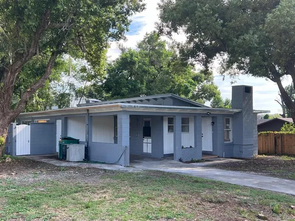 a view of a house with a yard and large tree