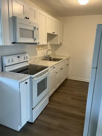 a kitchen with sink a microwave and cabinets