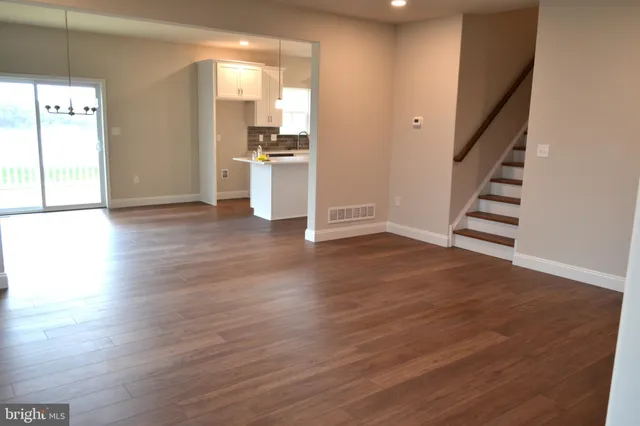 a view of a kitchen with wooden floor and stairs