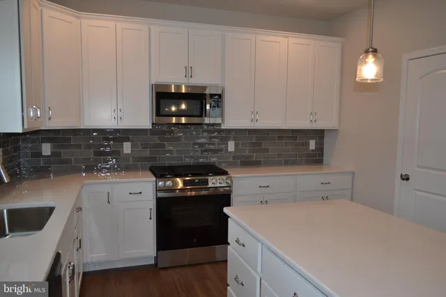 a kitchen with a stove and white cabinets
