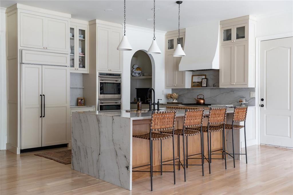 900 Crabapple Hill Alpharetta, GA 30004 - Photo 40 of 72 a kitchen with kitchen island granite countertop a refrigerator a stove a oven and white cabinets with wooden floor