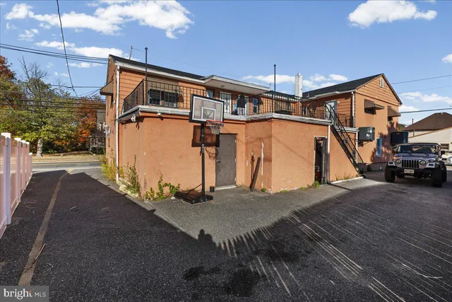 a view of a kitchen with kitchen island stainless steel appliances refrigerator stove and chairs