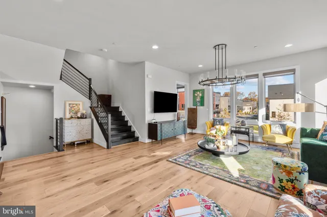 a kitchen with stainless steel appliances kitchen island granite countertop a sink a stove and a wooden floors