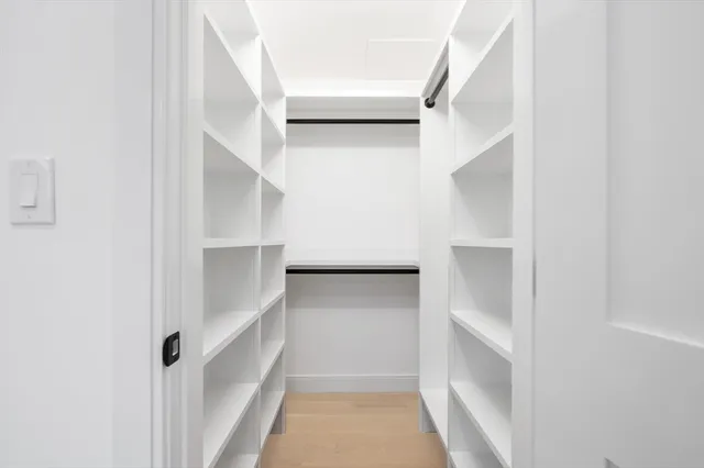 a view of walk in closet with empty racks