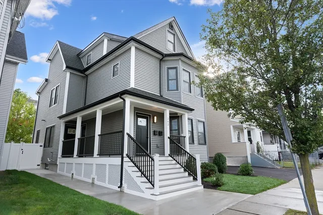 a view of a house with a yard and large tree