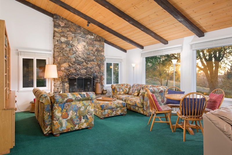2466 Wynola Road Julian, CA 92036 - Photo 13 of 25 Large living room with floor to ceiling wood-burning fireplace and picture windows.