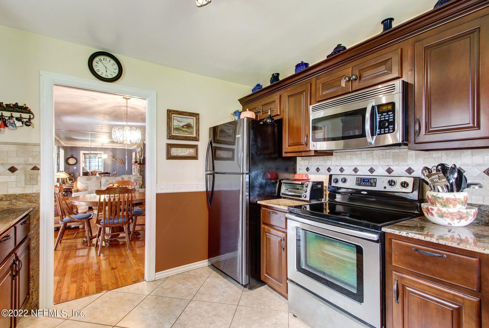 101 Orange Street Satsuma, FL 32189 - Photo 16 of 67 a kitchen with stainless steel appliances granite countertop a stove and a microwave