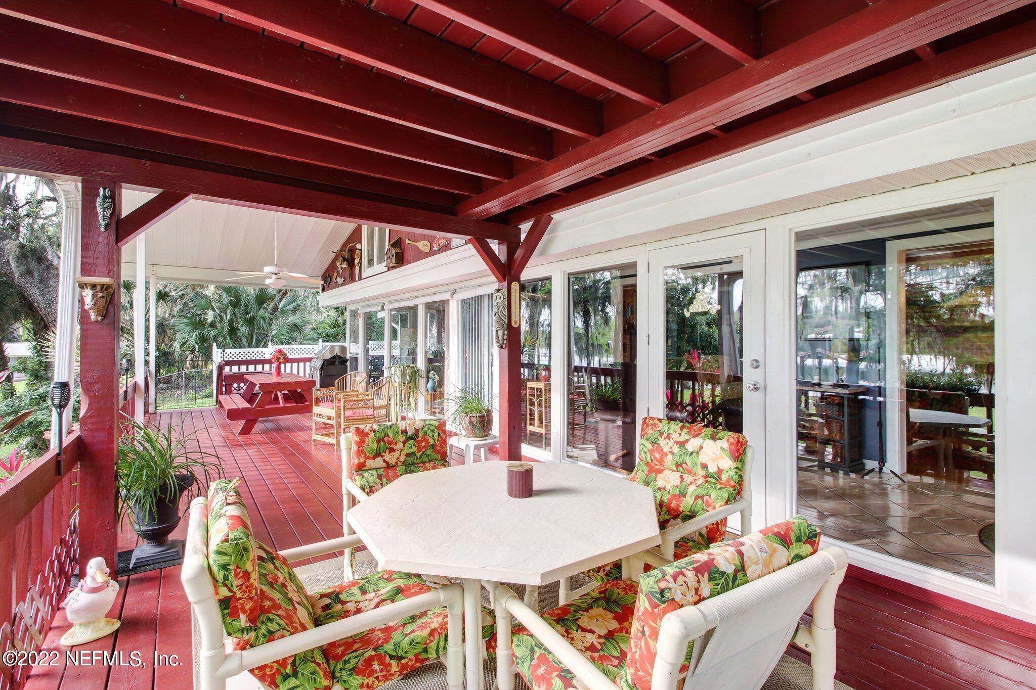 101 Orange Street Satsuma, FL 32189 - Photo 29 of 67 a view of a patio with table and chairs potted plants with wooden floor and floor to ceiling window