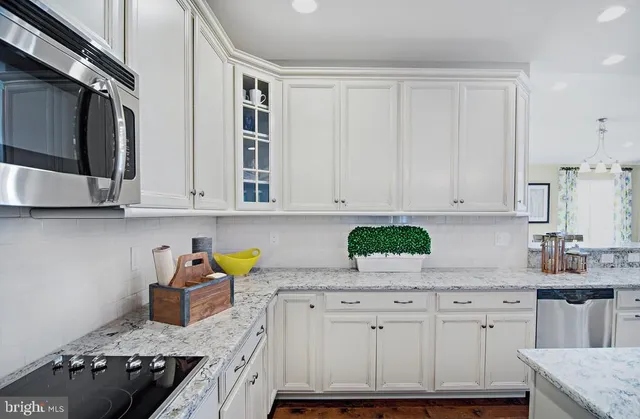a kitchen with granite countertop a sink stainless steel appliances and cabinets