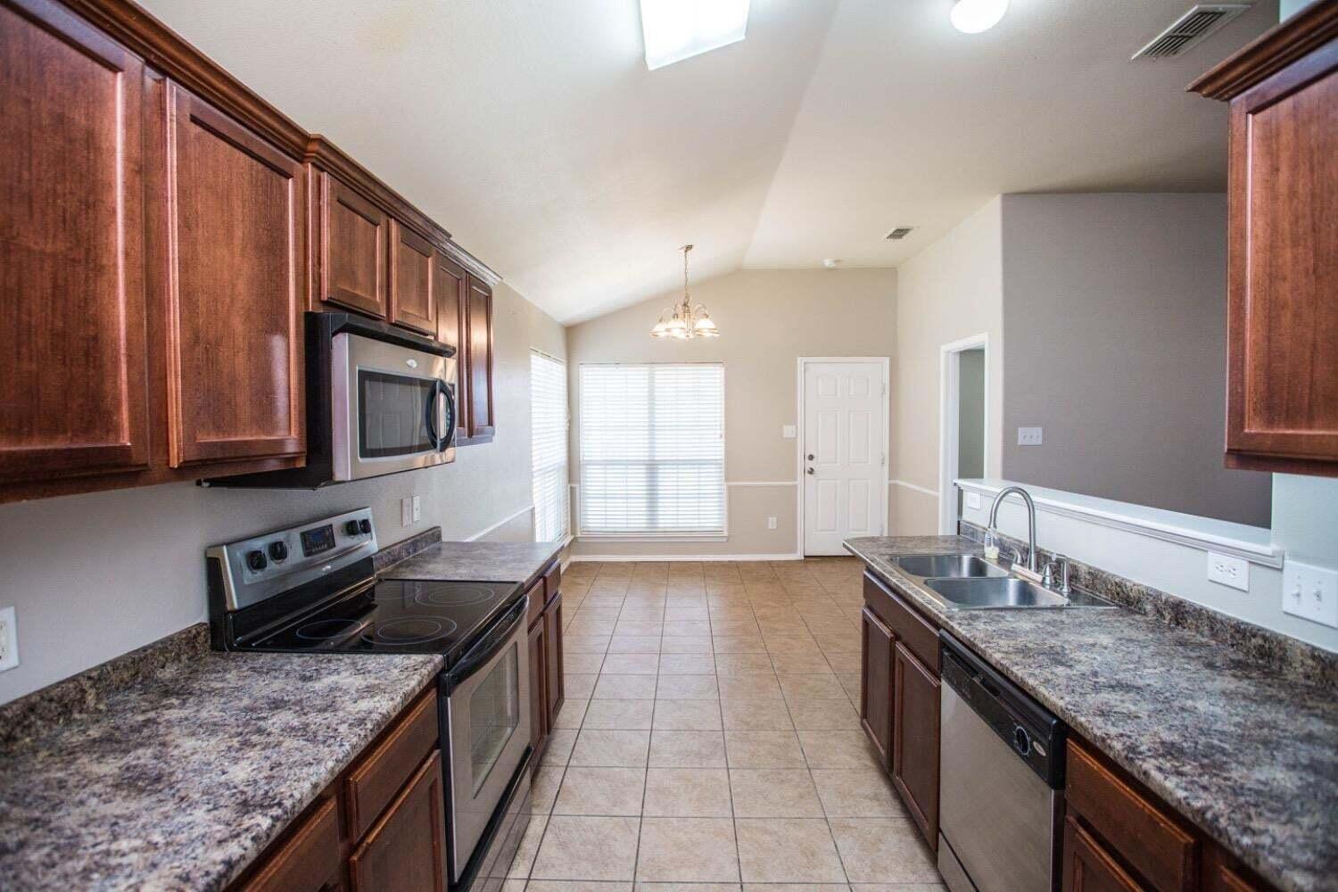 3606 Pontiac Avenue Lubbock, TX 79407 - Photo 5 of 17 a kitchen with granite countertop stainless steel appliances a sink a stove top oven a counter space and cabinets