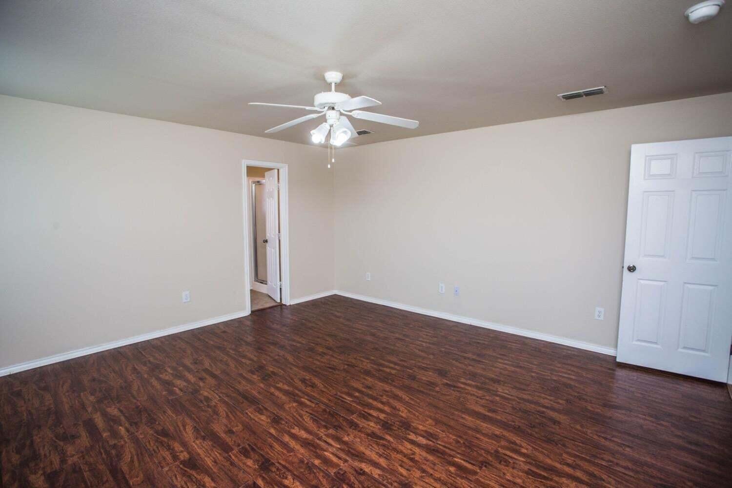 3606 Pontiac Avenue Lubbock, TX 79407 - Photo 9 of 17 an empty room with wooden floor fan and windows