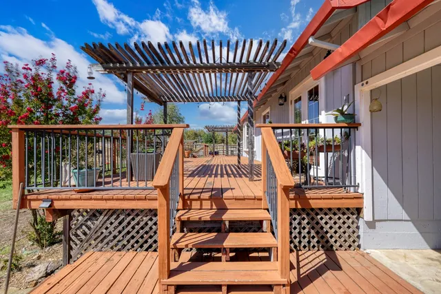 a view of a house with a wooden deck and a floor to ceiling window