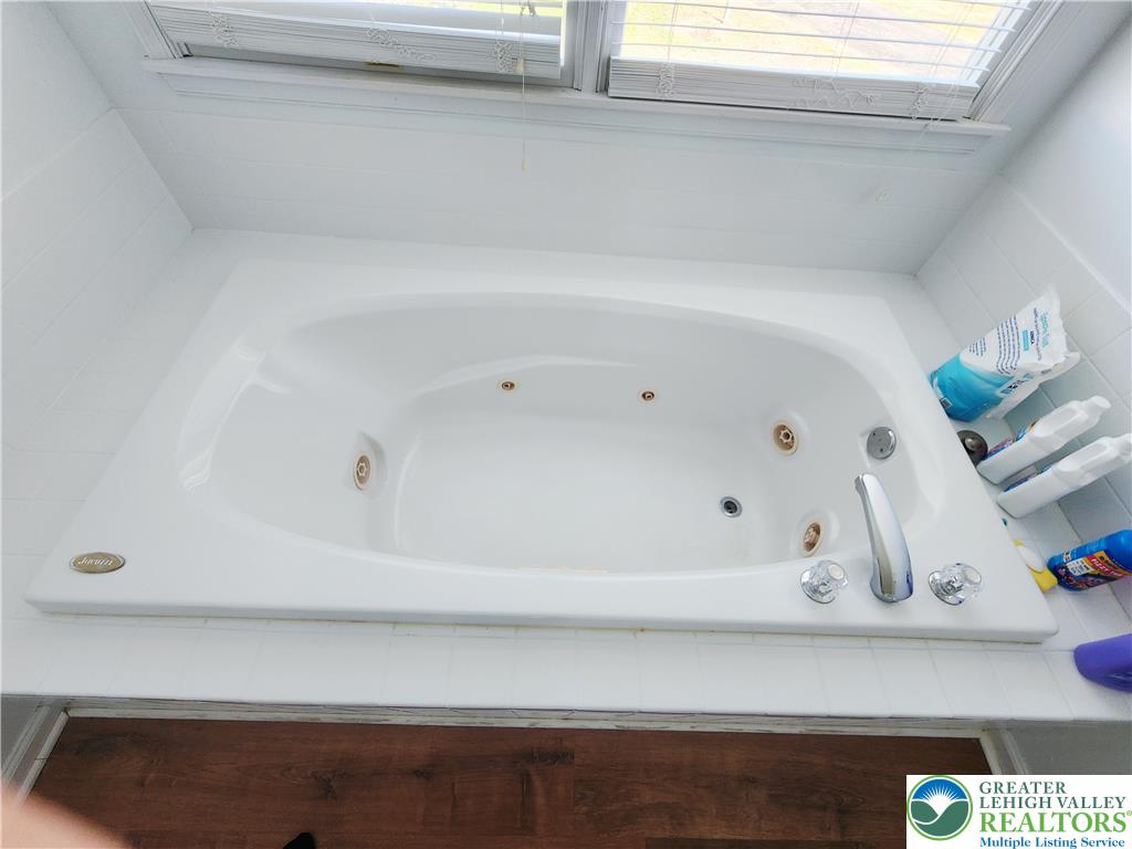 237 Ridings Circle Macungie, PA 18062 - Photo 42 of 70 A deep soaking tub sits beneath windows in this bathroom.