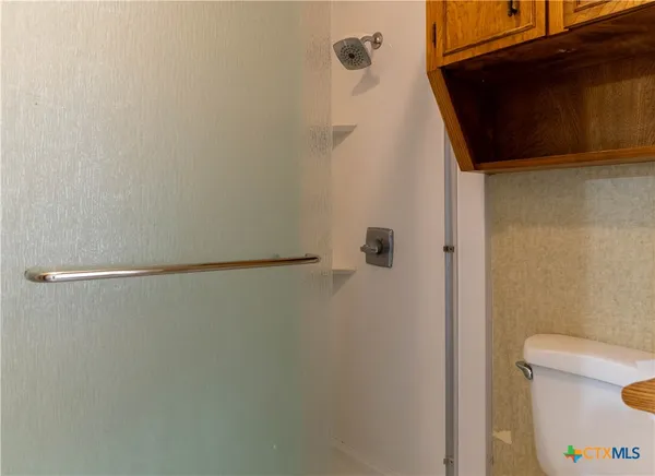an empty room with windows and chandelier fan