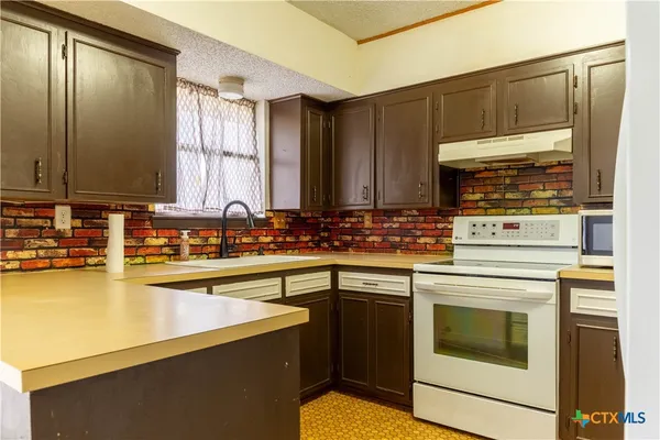 an empty room with closet and a chandelier fan