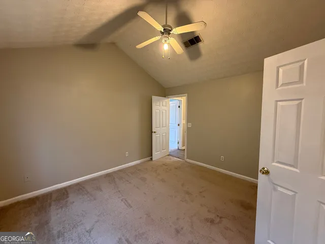 an empty room with a ceiling fan and a window