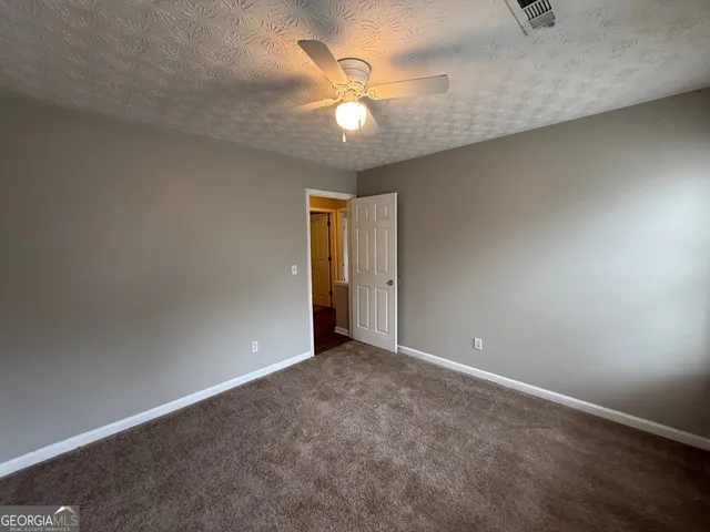 an empty room with closet and a chandelier fan