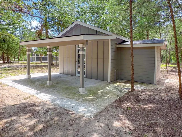 a view of a house with a yard and large tree